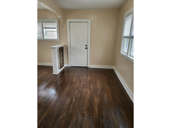 Dining room with laminate floor and adjacent to foyer area near bathroom.